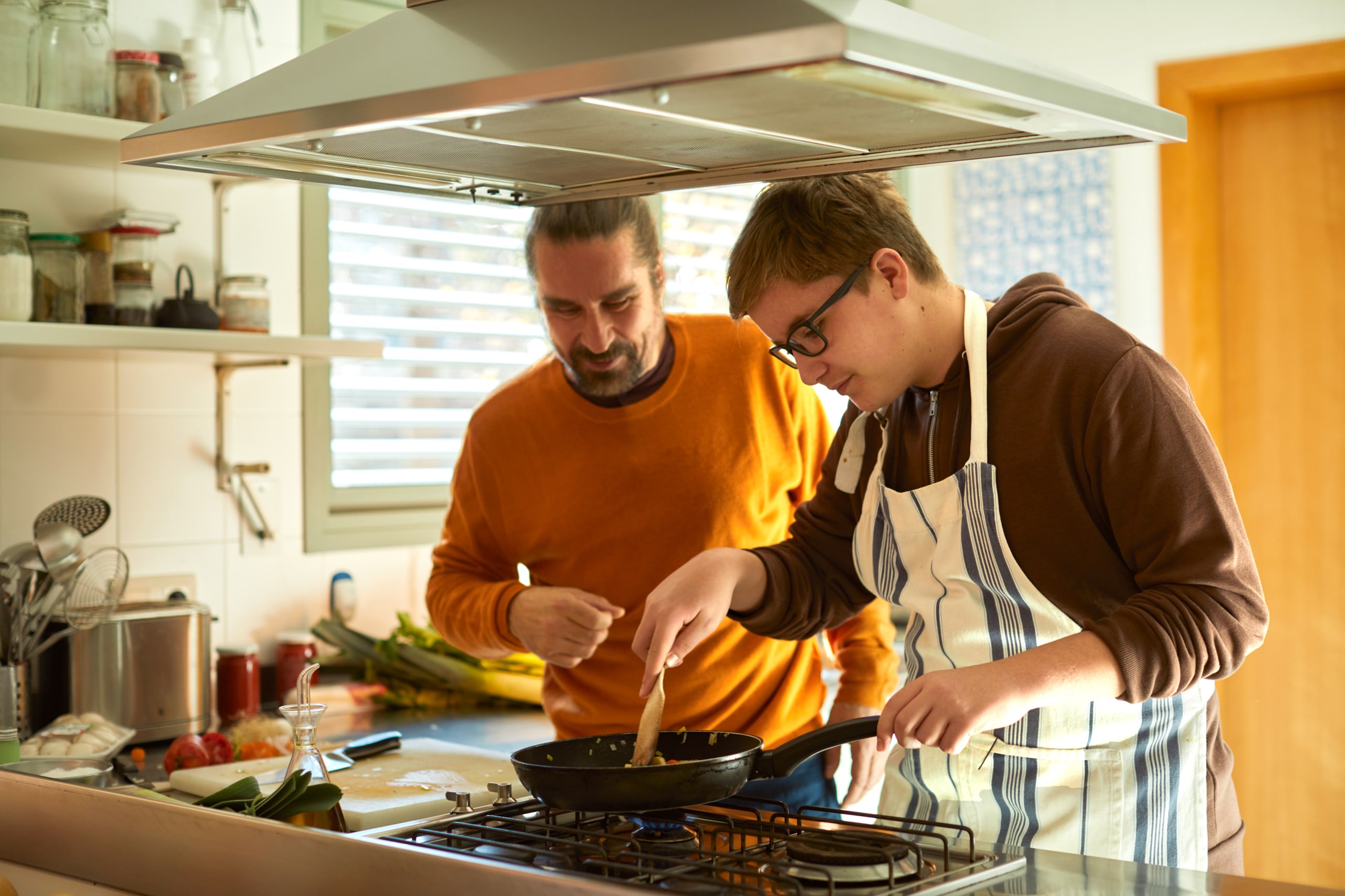 Young person cooking with support worker